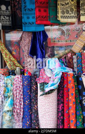 rotoli di tessuto colorato pronti per la vendita davanti a un negozio. Foto Stock