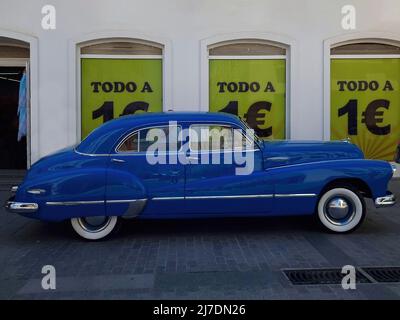 Elegante auto blu d'epoca parcheggiata davanti alla segnaletica con il testo in spagnolo 'todo a 1 euro' (tutto a 1 euro) Foto Stock