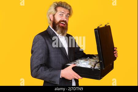 Uomo d'affari felice con la valigetta piena di soldi per il commercio. Dollaro valuta contanti. L'uomo ha preso il prestito. Foto Stock