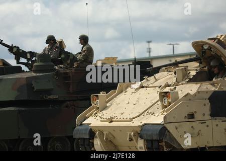 Dalla sinistra, lo staff dell'esercito degli Stati Uniti Sgt. Alex Jobe, comandante del carro armato e SPC. Arath Flores, pala caricatrice da 2nd Squadron, 11th Armored Cavalry Regiment, partirà per una prova su strada come PFC. Bryc Grant, pilota Bradley da 1st Squadron, 1st Cavallry Regiment, 1st Armored Division, attende di spostare il suo veicolo durante le attività di pesca del veicolo il secondo giorno della Sullivan Cup, a Fort Benning, GA., 26 aprile 2022. Durante il giorno 2, gli equipaggi della Sullivan Cup hanno una disposizione delle attrezzature, disegna veicoli e conduce PMC (Preventive Maintenance Cheques), per garantire che i loro veicoli saranno pronti per la gara. Foto Stock