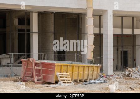 Contenitore in metallo per rifiuti da costruzione, macerie vicino a un cantiere. Foto Stock