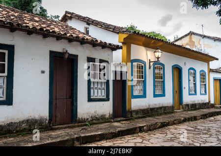 Tipiche case coloniali colorate affiancate in via Direita nel centro storico di Tiradentes sotto il cielo nuvoloso. Foto Stock