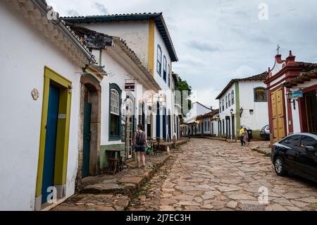 Piccola impresa locale che si trova in edifici coloniali affiancati a Direita Street nel centro storico di Tiradentes e sotto il cielo nuvoloso. Foto Stock