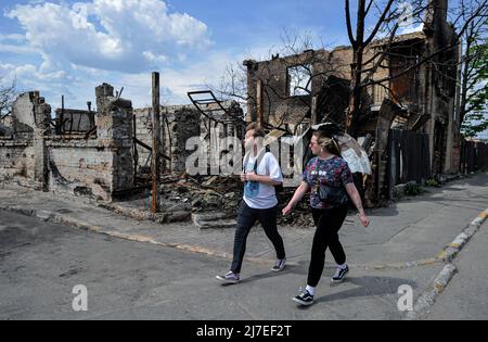 La gente cammina davanti a una casa distrutta che è stata danneggiata a causa della caduta dell'esercito russo nella città di Irpin, vicino alla capitale Ucraina Kiev. La Russia ha invaso l'Ucraina il 24 febbraio 2022, scatenando il più grande attacco militare in Europa dalla seconda guerra mondiale (Foto di Sergei Chuzavkov / SOPA Images/Sipa USA) Foto Stock