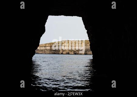 Uscita dal Dwejra Inland Sea visto da una barca sull'isola di Gozo, Malta nell'aprile 2022. Foto Stock