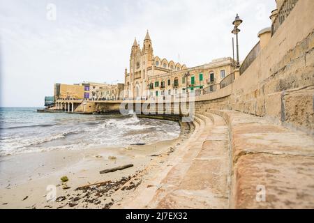 Onde sotto Knisja tal-Karmnu a Balluta Bay a Malta visto nel mese di aprile 2022. Foto Stock