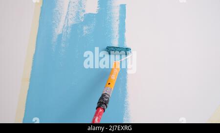 Parete dipinta a mano. Pittura pareti con rullo in blu Foto Stock
