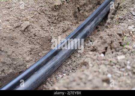 Infrastruttura di comunicazione e comunicazione in fibra ottica con tubo fognario in pvc nero Foto Stock