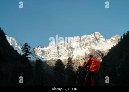 vista posteriore del trekking asiatico guardando il monte jiawaren-an, parte delle montagne di neve meili nella provincia di yunnan, cina Foto Stock