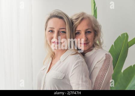mamma e figlia si abbracciano guardando insieme la camerra . Foto di alta qualità Foto Stock
