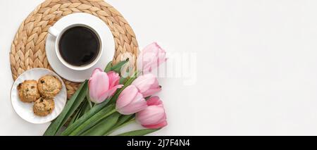 Mani donna, tazza di caffè, tulipani rosa su sfondo bianco. Caffè del mattino sul vassoio di vimini. Vista dall'alto. Disposizione piatta. Arredamento elegante per la casa. Foto Stock