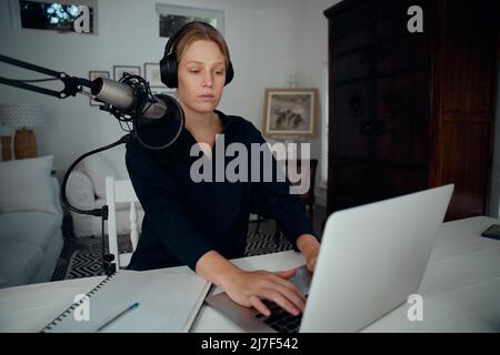 Podcaster femmina caucasico che lavora da casa Foto Stock