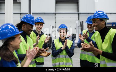 Team di ingegneri multirazziali che lavorano in fabbrica robotica - Tech Industrial Concept Foto Stock