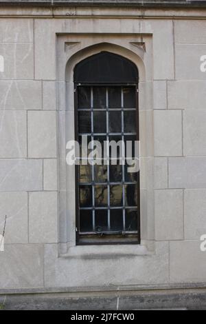 Finestre gotiche medievali con vetri su un muro di pietra in bianco e nero. Foto Stock