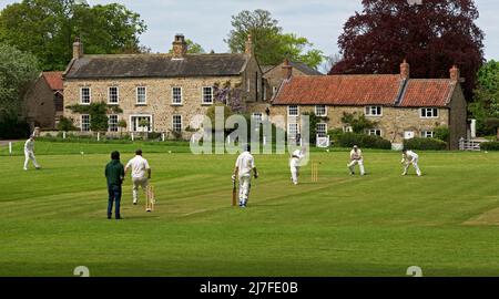 Partita di cricket in corso nel villaggio di Crakehall, North Yorkshire, Inghilterra Regno Unito Foto Stock