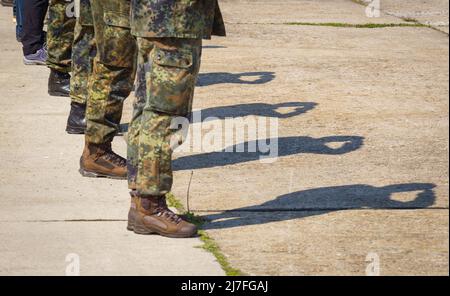 Hardheim, Germania. 09th maggio 2022. I membri della Bundeswehr salutano alla riapertura cerimoniale del deposito di materiale Hardheim, mentre una banda militare suona l'inno nazionale. Come parte del riorientamento della Bundeswehr alla difesa nazionale e dell'alleanza, il campo di Hardheim e il vicino deposito di munizioni di Altheim sono stati rimessi in servizio. Credit: Frank Rumpenhorst/dpa/Alamy Live News Foto Stock