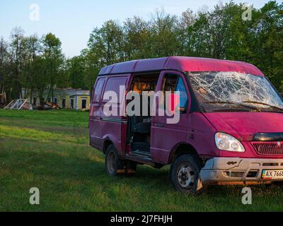 Regione di Kharkiv, Skovorodinovka, Skovorodinivka, Ucraina - 05.07.2022: Veicolo civile rosso rotto ha distrutto l'automobile con vetro incrinato risultato Foto Stock