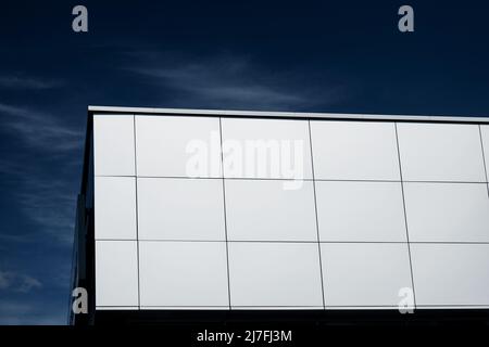 pareti esterne di un edificio contemporaneo di stile commerciale con pannelli compositi in alluminio su sfondo cielo Foto Stock