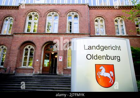 Oldenburg, Germania. 09th maggio 2022. Un cartello con lo stemma della bassa Sassonia si trova di fronte all'ingresso del tribunale regionale di Oldenburg, dove continua il processo per due conteggi di omicidio. Si dice che l'imputato abbia prima pugnato un presunto rivale in un bar a Delmenhorst nell'ottobre 2021. Poi ha ferito il suo compagno così severamente con un coltello che è morta due giorni dopo. Credit: Hauke-Christian Dittrich/dpa/Alamy Live News Foto Stock