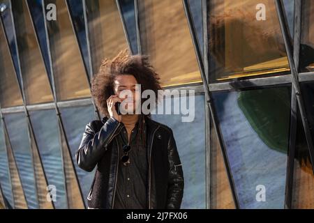 Giovane uomo che parla tramite telefono cellulare Foto Stock