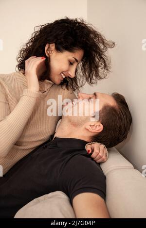 Coppia sorridente abbracciante sul divano Foto Stock