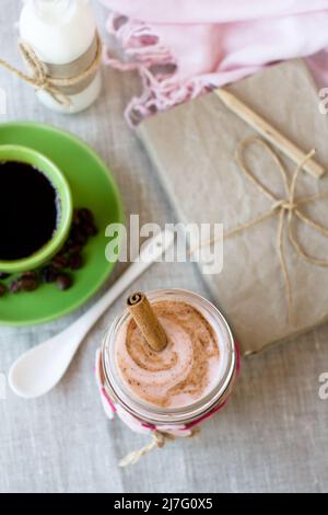 Colazione nutriente: Farinata d'avena con yogurt alla bacche e cannella, caffè nero e una bottiglia di latte. Foto Stock