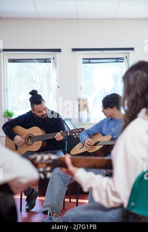 Adolescenti che frequentano una lezione di chitarra Foto Stock