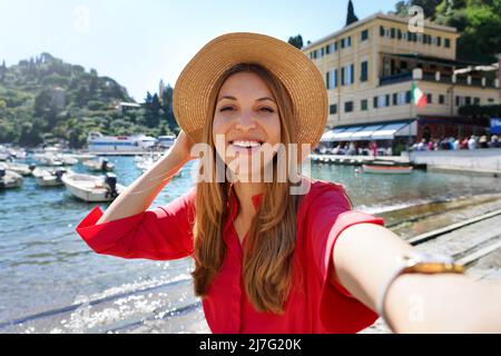 Portofino ragazza turistica scattando foto selfie sulla famosa destinazione di lusso. Attrazione turistica europea in Italia. Giovane donna in vacanza. Foto Stock