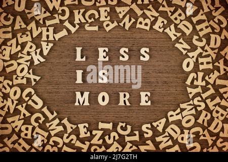'Meno è più' frase fatta con lettere di legno sul tavolo, concetto. Foto Stock