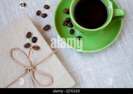 Tazza di caffè verde con chicchi di caffè e taccuino vintage Foto Stock