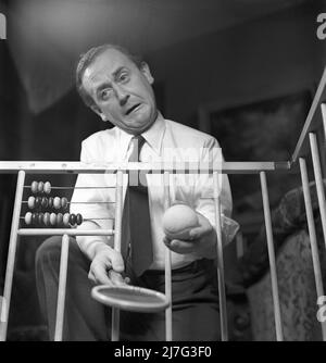 Padre nel 1940s. L'attore Åke Söderblom, 1910-1965 prova il suo meglio a divertire suo figlio da fuori del playpen. Svezia 1949 AN92-4 Foto Stock