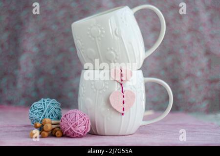 Tre cuori rossi lavorati a maglia su sfondo grigio di legno, simboleggiano  l'amore e la famiglia. Relazione di famiglia, legami. San Valentino. Aghi  per maglieria e un Foto stock - Alamy