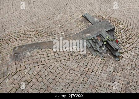 Croce commemorativa di bronzo dedicata agli studenti cecoslovacchi Jan Palach e Jan Zajíc accanto alla costruzione del Museo Nazionale (Národní muzeum) in Piazza Venceslao (Václavské náměstí) a Praga, Repubblica Ceca. Jan Palach si suicidò per autoimmolazione il 16 gennaio 1969 come protesta contro l'invasione sovietica in Cecoslovacchia il 21 agosto 1968. Jan Zajíc lo seguì il 25 febbraio 1969. La croce commemorativa disegnata dall'artista ceco Barbora Veselá è stata svelata il 16 gennaio 2000 vicino al luogo in cui Jan Palach si suicidò. Foto Stock