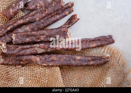 South African Dry Wors, uno spuntino di salsiccia secca e stagionata sul grigio, con spazio copia Foto Stock