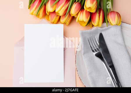 Mockup per le congratulazioni invito o menu. Carta vuota in busta con un'elegante impostazione da tavolo. Foto Stock