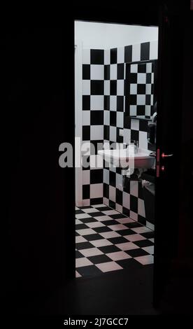 Bagno moderno con piastrelle bianche e nere a scacchi su pareti e pavimento. Foto Stock