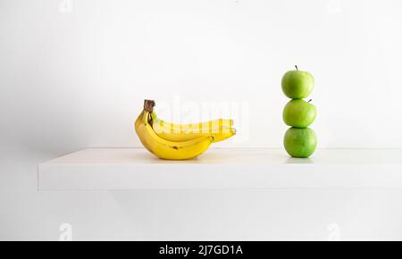 Mele verdi e banane su sfondo bianco primo piano. Foto Stock