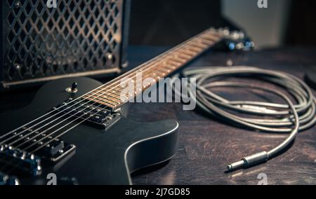 Primo piano, chitarra elettrica nera su sfondo scuro. Foto Stock