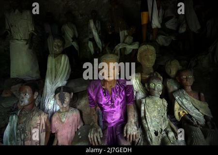 Il legno effige all'interno di una grotta in un sito di sepoltura tradizionale nel villaggio di Kete Kesu, Toraja Nord, Sulawesi Sud, Indonesia. Foto Stock