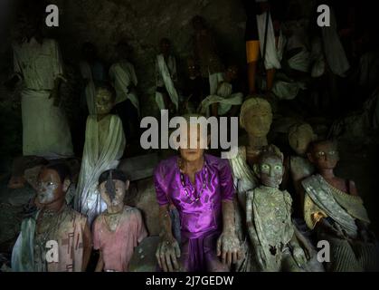 Il legno effige all'interno di una grotta in un sito di sepoltura tradizionale nel villaggio di Kete Kesu, Toraja Nord, Sulawesi Sud, Indonesia. Foto Stock