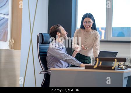 Il direttore dell'azienda ha avuto una conversazione con la sua assistente femminile Foto Stock