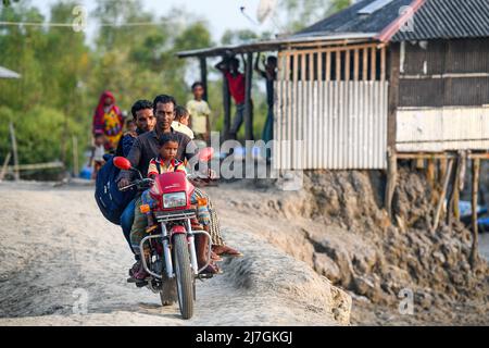 Satkhira, Bangladesh. 6th maggio 2022. La gente ha visto viaggiare in motocicletta sulla strada sterrata con i propri figli a rischio a Shyamnagar nel distretto di Satkhira, Bangladesh. (Credit Image: © Piyas Biswas/SOPA Images via ZUMA Press Wire) Foto Stock