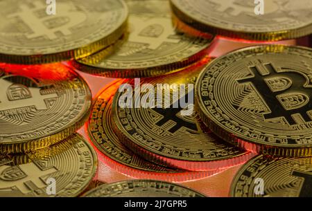 Bitcoin Cryptocurrency primo piano con sfondo rosso incandescente significa un calo del mercato orso nel prezzo di negoziazione Foto Stock