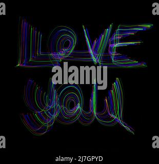 Le parole "Love You" scritte in aria con percorsi di movimento colorati al neon su sfondo nero Foto Stock