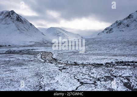 Splendida immagine aerea del paesaggio dei droni di Stob Dearg e Glencoe nelle Highlands scozzesi durante le profonde nevicate e i bellissimi cieli blu Foto Stock