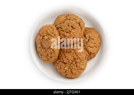 biscotti di farina d'avena in recipiente di ceramica isolato su sfondo bianco con percorso di taglio e profondità di campo completa. Vista dall'alto. Disposizione piatta Foto Stock