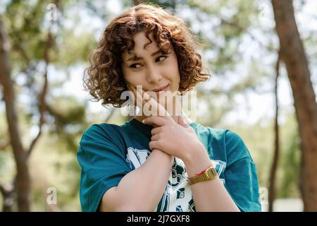 Giovane bella donna rossa hanno un mal di denti sul parco della città, all'aperto. Donna che soffre di mal di denti, carie dentali o sensibilità. Foto Stock