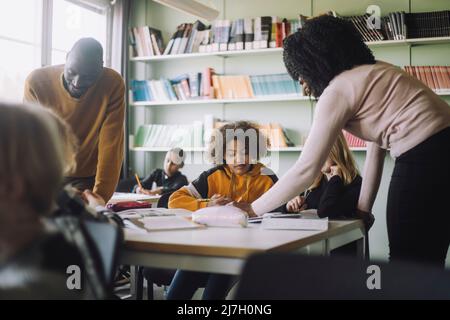 Insegnanti che insegnano gli studenti in classe a scuola Foto Stock