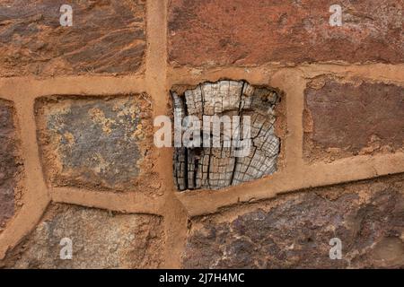 dettaglio di arancione sollevato puntando utilizzato tra la costruzione di pietra di costruzione e travi di legno Foto Stock