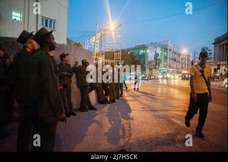 Le guardie militari cubane su una strada a l'Avana, Cuba vicino all'Università dell'Avana con una grande fotografia del leader cubano Fidel Castro su un edificio. Foto Stock